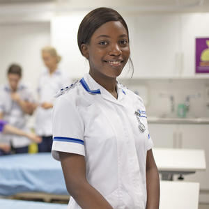 A female student is wearing a nurses uniform and is training to be a nurse is one of our clinical skills room used on our nursing degree.