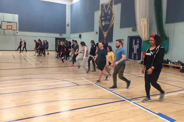 A group of student occupational therapists doing a walking exercise in the sports hall on our occupational therapy degree.