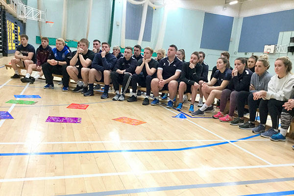 Group of PGCE Secondary Physical Education students sitting on benches in sports halls