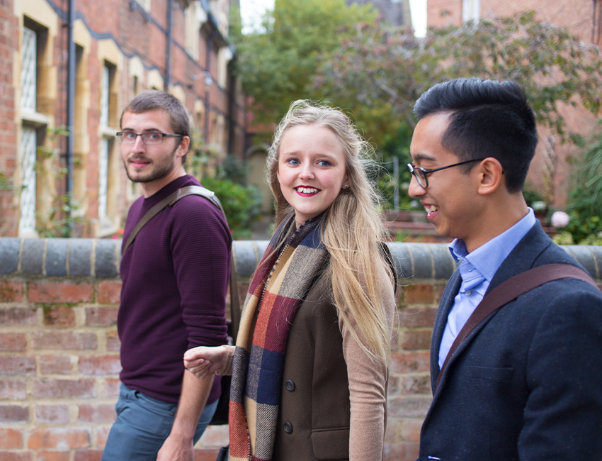 Three students walking through a street in Worcester