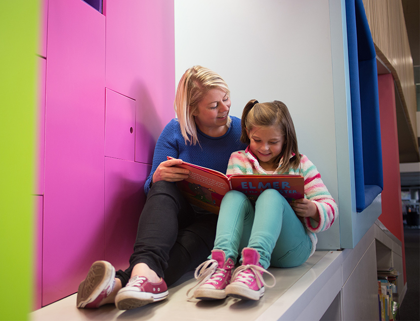 A woman reading to a child in The Hive
