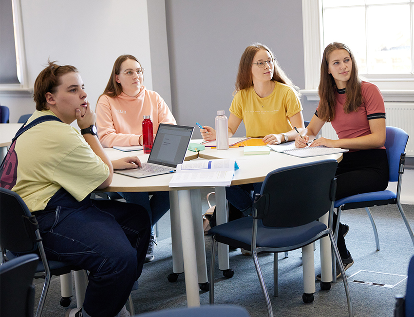 Four students sat around a table in the classroom