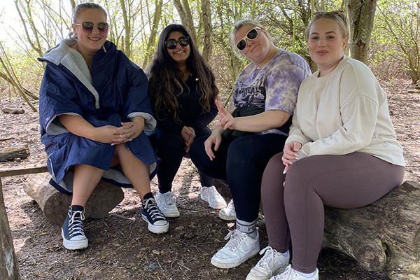 4 students are sitting on a log