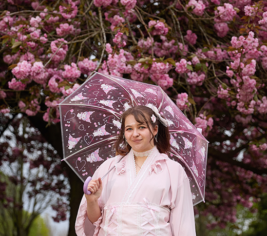 Study Abroad student wearing a kimono while standing in front of cherry blossoms