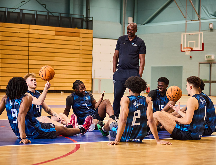 a man stood amongst a group of basketball players