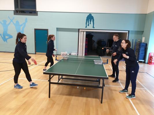 4 students playing table tennis