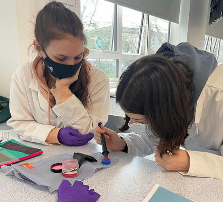 Two students wearing masks are working on some fingerprints