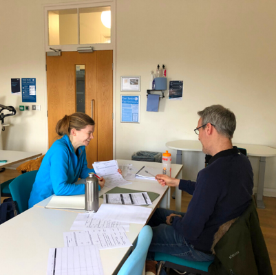 Nutritional Therapy consultation with a man and woman sat facing each other at a table