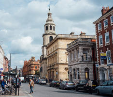 A shot of the street called The Cross at Worcester. The buildings are varied and one has a tower.