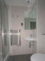 inside a bathroom with pink walls and including a sink and a handrail