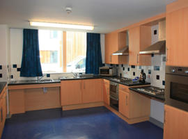 inside a kitchen with a view of fitted cupboards and a window