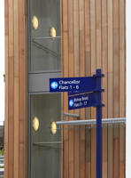 blue signs in front of a tall brown building