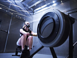 girl wearing a mask on a rowing machine
