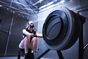 girl wearing a mask on a rowing machine