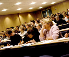 inside a lecture theatre with multiple students at their desks