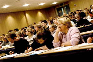 inside a lecture theatre with multiple students at their desks