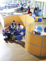 elevated view of students on blue seats in front of a yellow partition