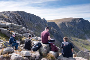 students studying on rocks on a mountain