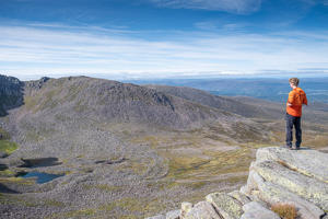 student standing on a rock and admiring the view of mountains