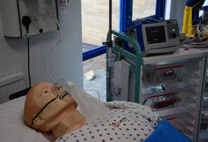 Synthetic patient lying down and wearing a mask