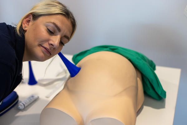 Midwifery student practicing listening to baby's heartbeat