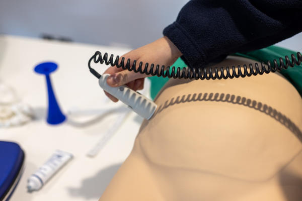 Close-up of midwifery student practicing using a doppler