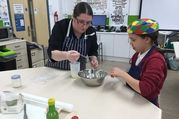 teacher and pupil with a silver mixing bowl