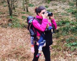 woman in pink top and rucksack holding a camera