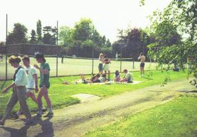 Students socializing outside by a football pitch in the 1990s