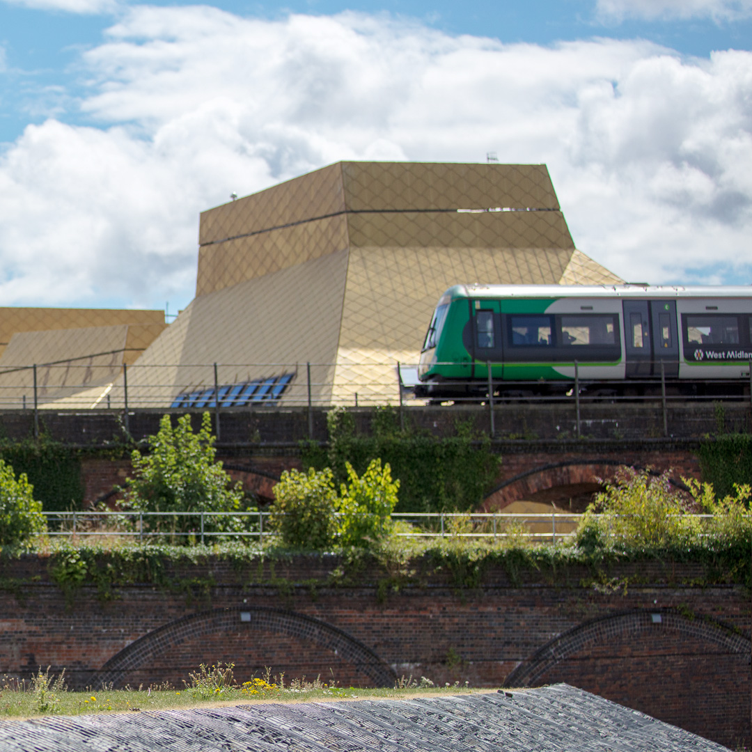 A train passing on the rail bridge beside the Hive library