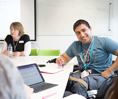 a smiling man is helping a student