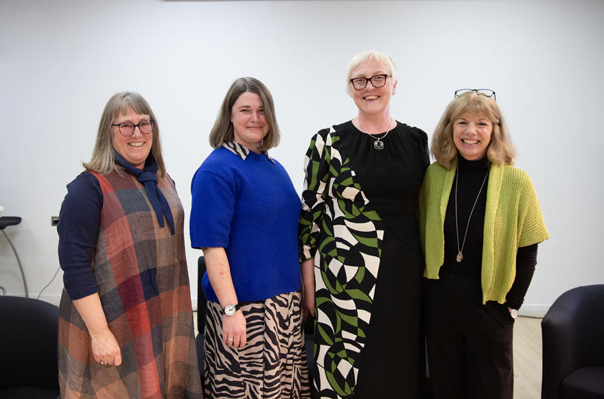 Four people standing together posed for a picture