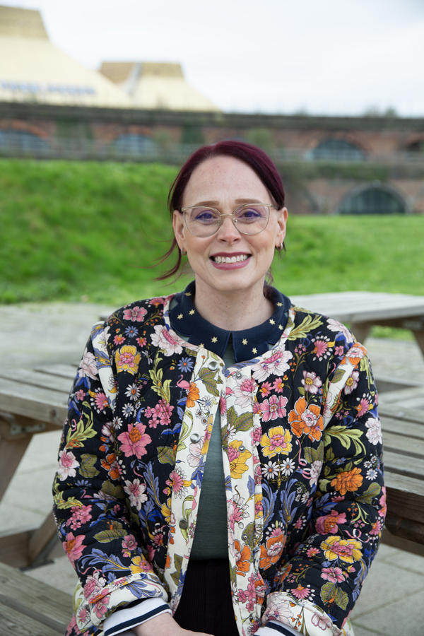 Person sat on bench with arches in distance behind