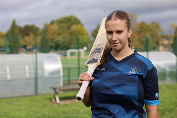 Person holding cricket bat on shoulder