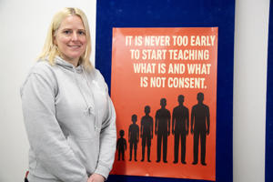 Person standing next to poster