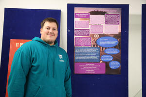 Person standing next to poster