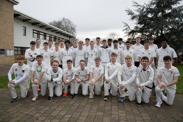 Group of people gathered in a courtyard with building behind them