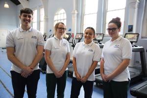 four students in white shirts standing in a line