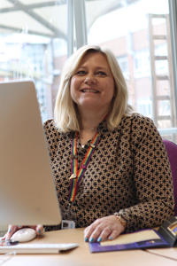 Helen Holmes sat by computer