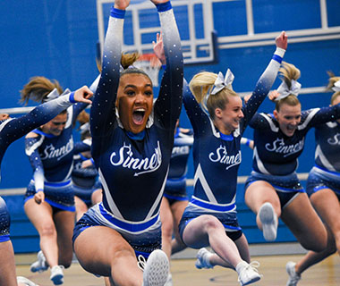 A group of cheerleaders are cheering