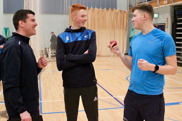 Coach Craig Williams is in a discussion with students Jake and Charlie