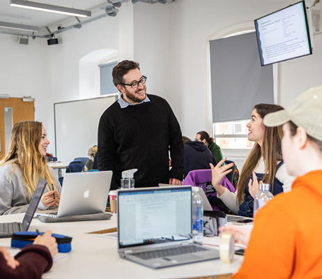 Jack MacGowan talks animatedly to a student in a lecture