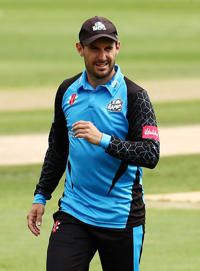 A man in a blue top is playing cricket