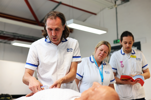 Mature student nurses working with a dummy patient