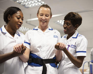 Two nurses are helping another nursing student