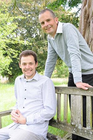 Lecturer standing beside student on an outdoor bench