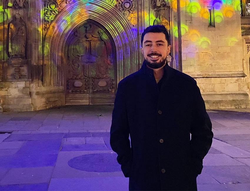 Image of Shane wearing a black coat, stood in a cathedral