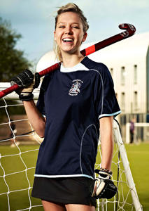 A girl holding a hockey stick is smiling