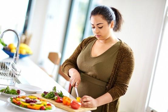 A woman is cutting vegetables