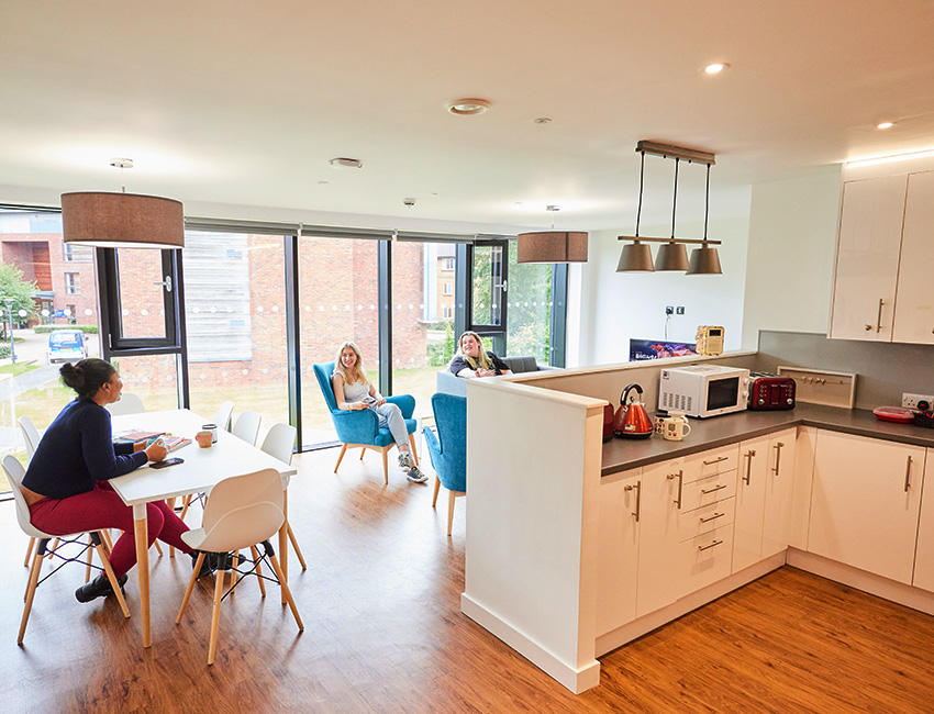 Students sat relaxing in large dining,kitchen and living room area